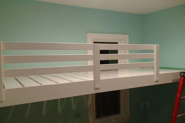 there is a white bunk bed in the room with blue walls and green paint on the walls