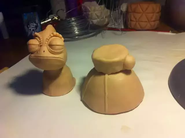 two clay sculptures sitting on top of a table