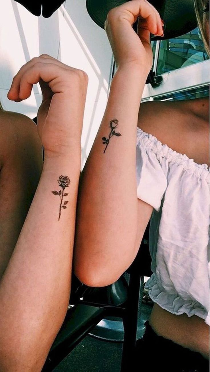 two women with tattoos on their arms sitting next to each other and one has a flower tattoo on her arm