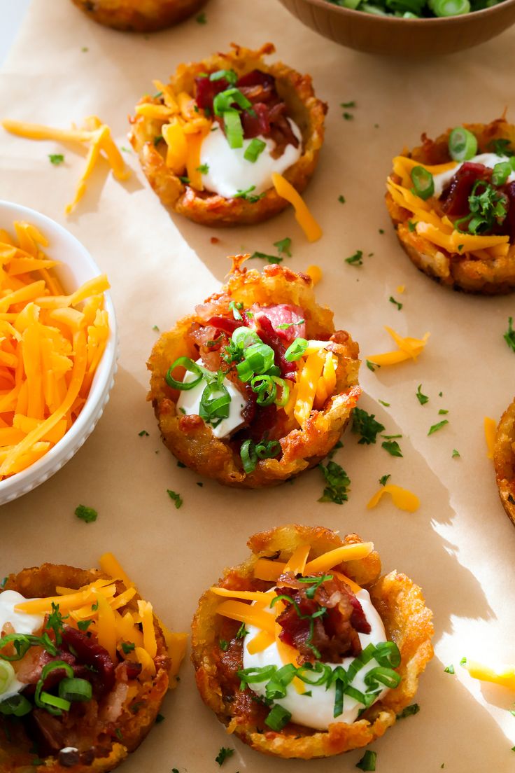 small appetizers with cheese and other toppings on a sheet of parchment paper