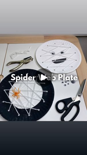 there is a spider web plate on the table with scissors and other crafting supplies