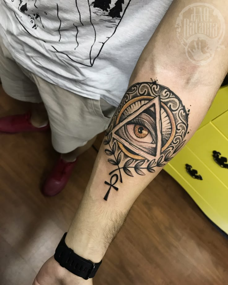 a man's arm with an all seeing eye tattoo on it