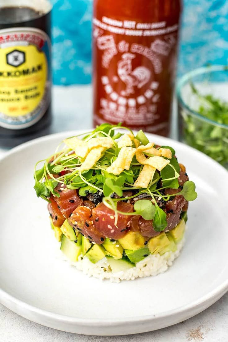 a white plate topped with rice covered in veggies next to a bottle of ketchup