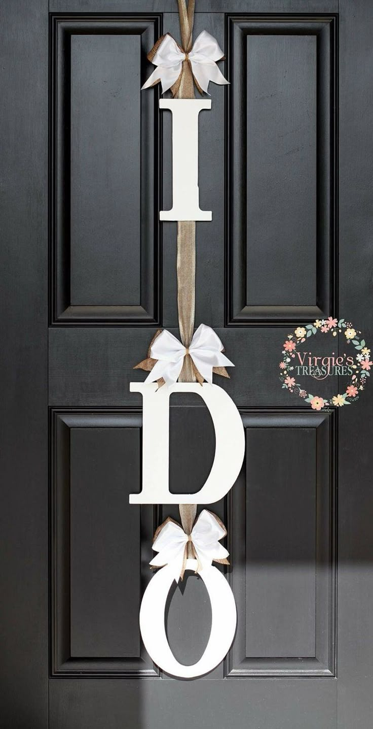 a door hanger with the letter d and bow hanging from it's side