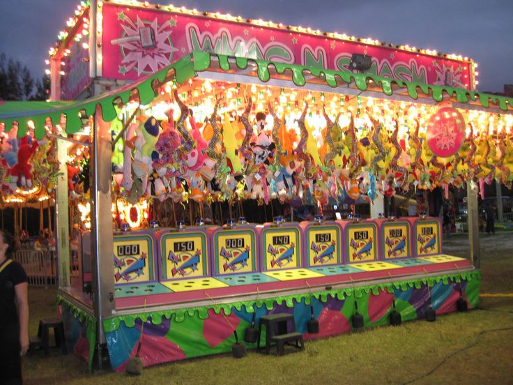 a carnival ride at night with people standing around it and onlookers in the background