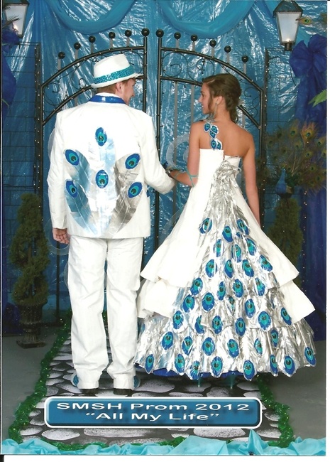 a man and woman dressed up as peacocks in front of a blue stage backdrop