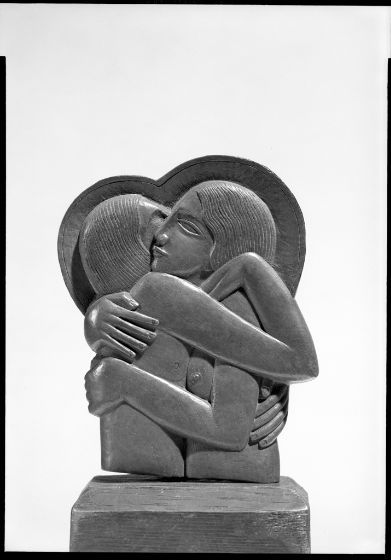 a black and white photo of a statue with a heart on it's back