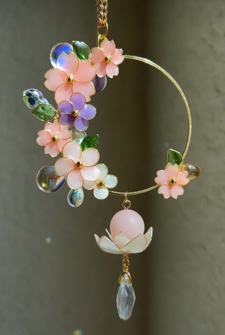 a close up of a wind chime with flowers and beads hanging from it's side