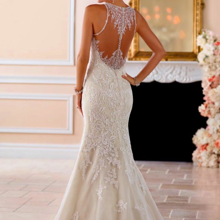 a woman in a wedding dress looking back at the bride's gown and veil