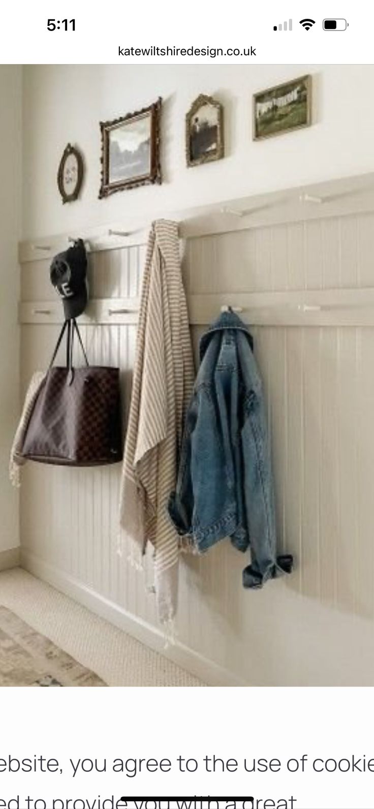 an image of a coat rack with coats hanging on the wall and pictures above it