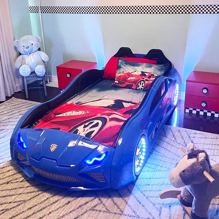 a blue car bed in a child's bedroom