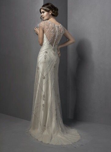 the back of a woman's wedding dress, with an intricate beaded design