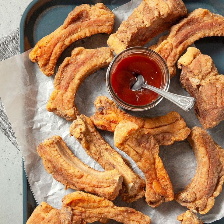 chicken wings with ketchup and sauce on a blue tray, ready to be eaten