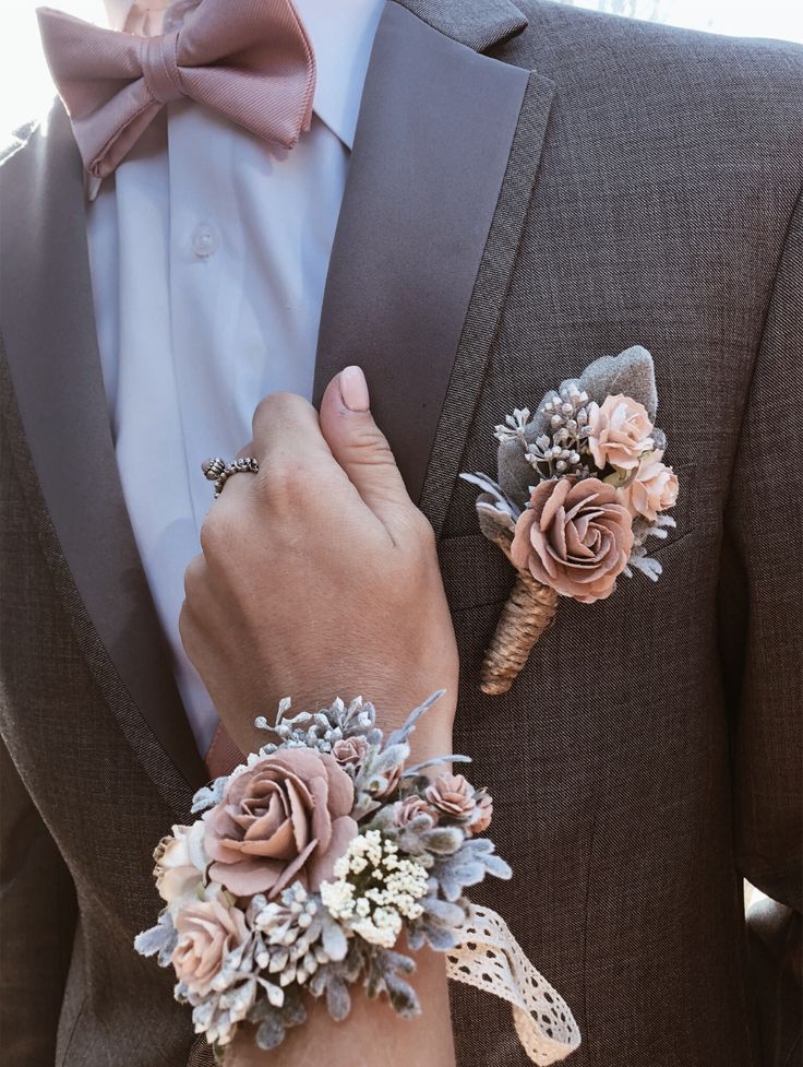 a man in a tuxedo with two boutonnieres on his lapel