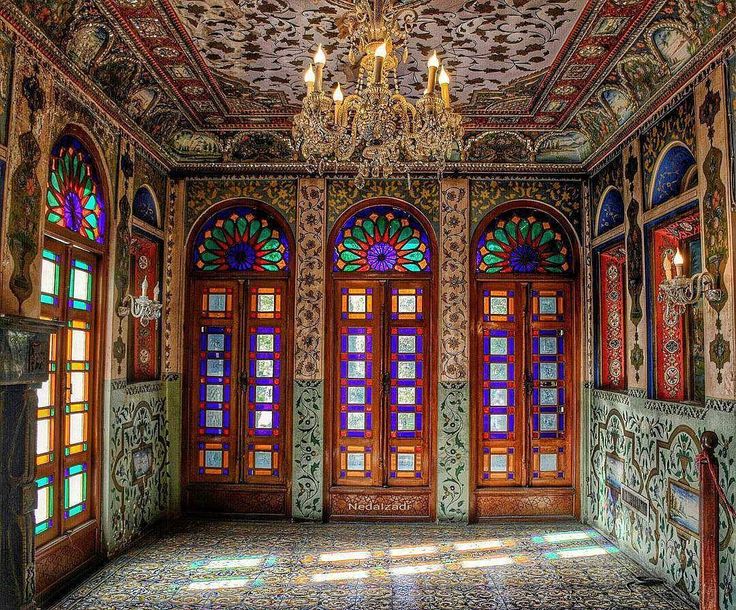 an ornately decorated room with stained glass doors and chandelier hanging from the ceiling