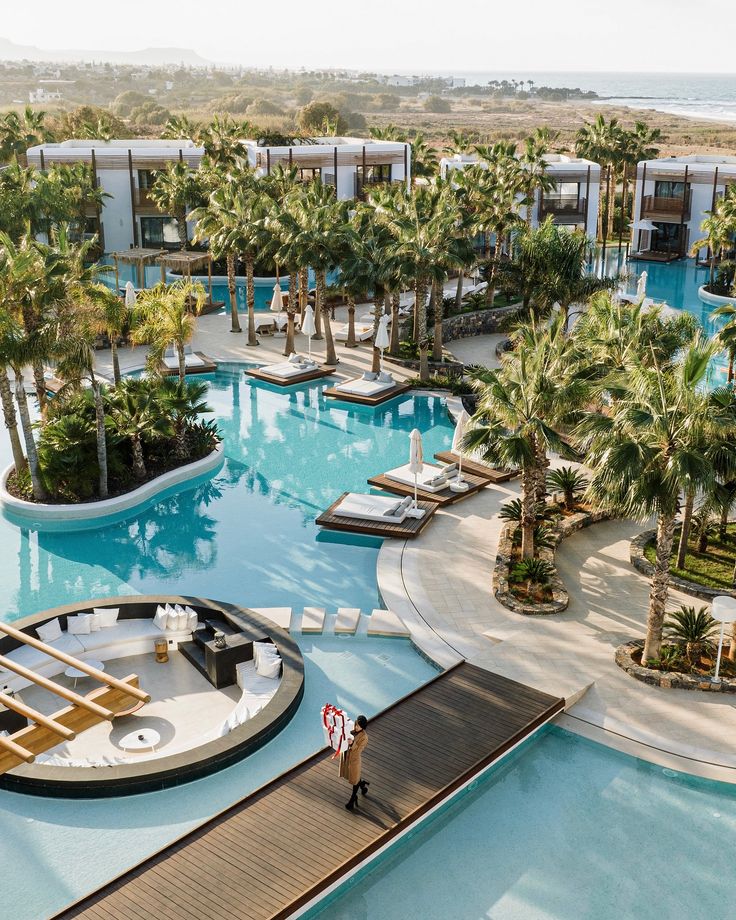 an aerial view of a resort pool surrounded by palm trees