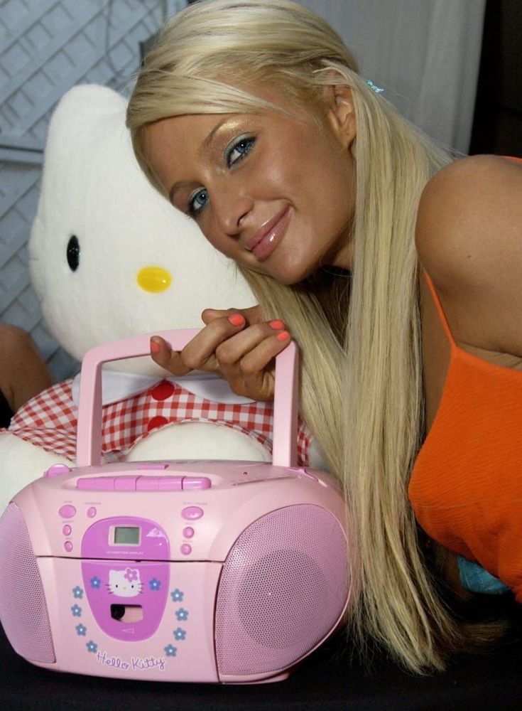 a woman laying on the ground next to a pink radio and a white teddy bear