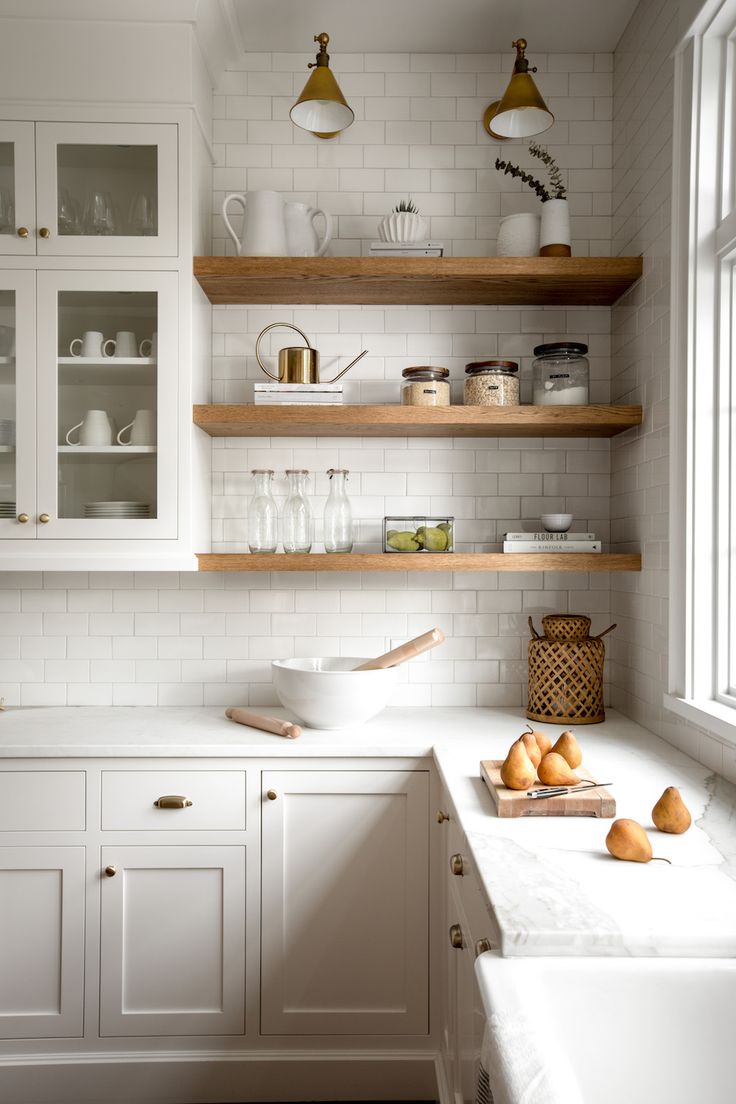 the kitchen is clean and ready to be used for cooking or baking, with white cabinets and open shelves