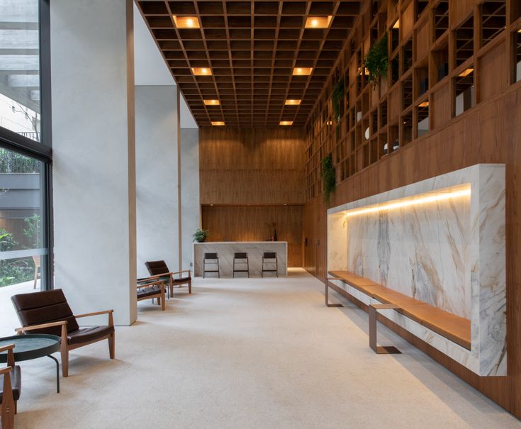 an empty lobby with chairs and tables in it