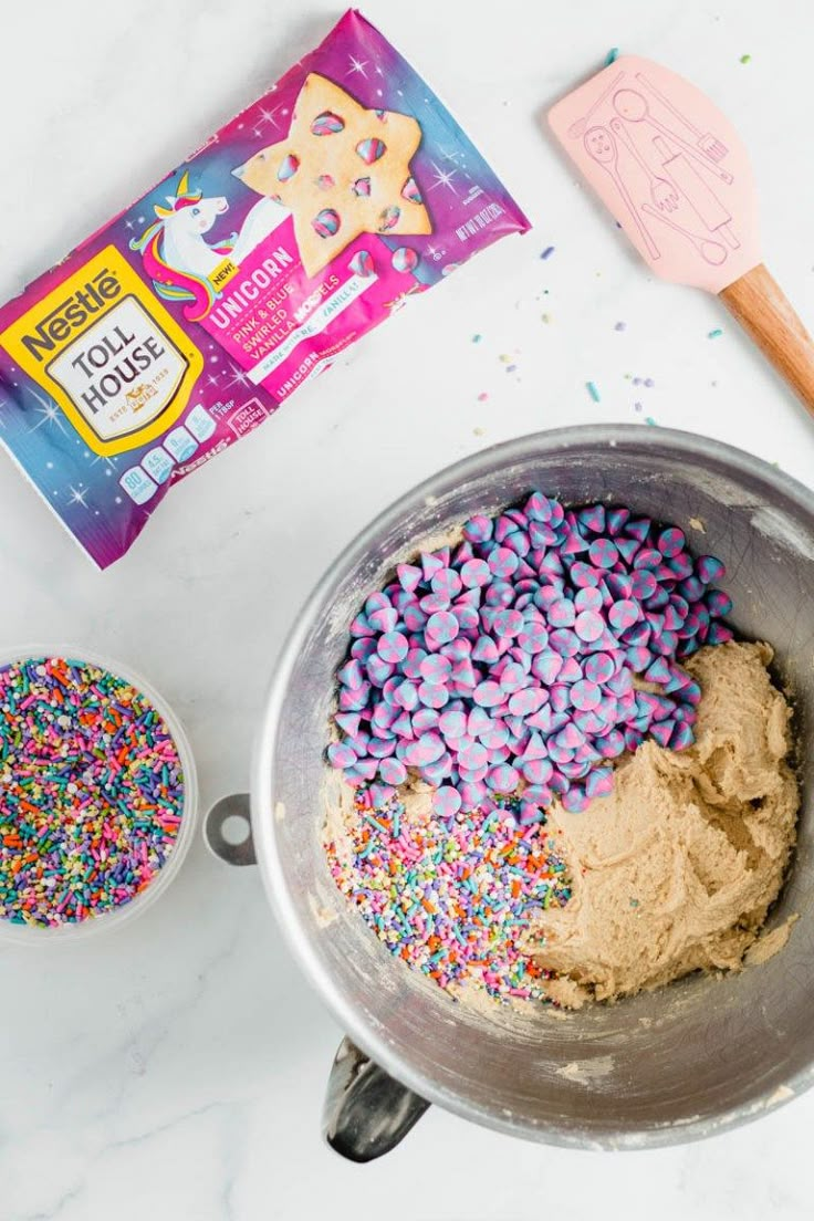 a bowl filled with sprinkles next to a bag of cookie dough