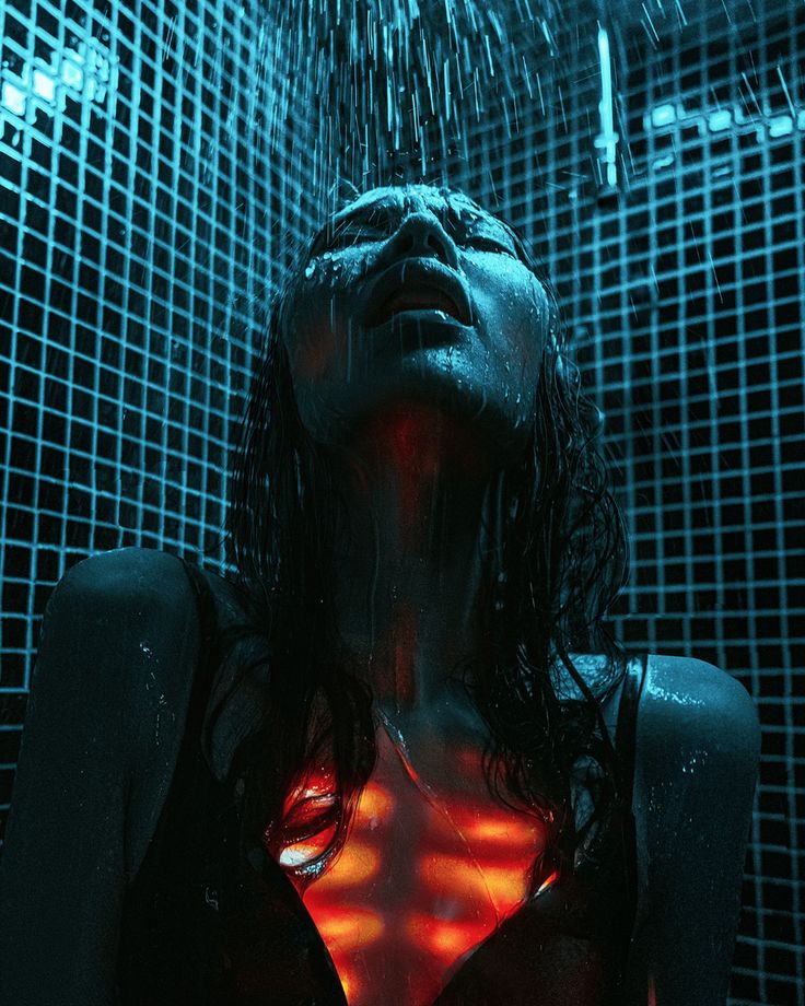 a woman is standing in the shower with her back to the camera and glowing under water