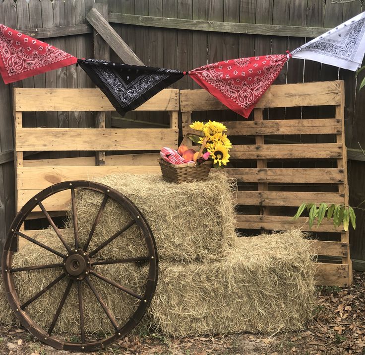 a wagon with hay and flowers on it in front of a fence