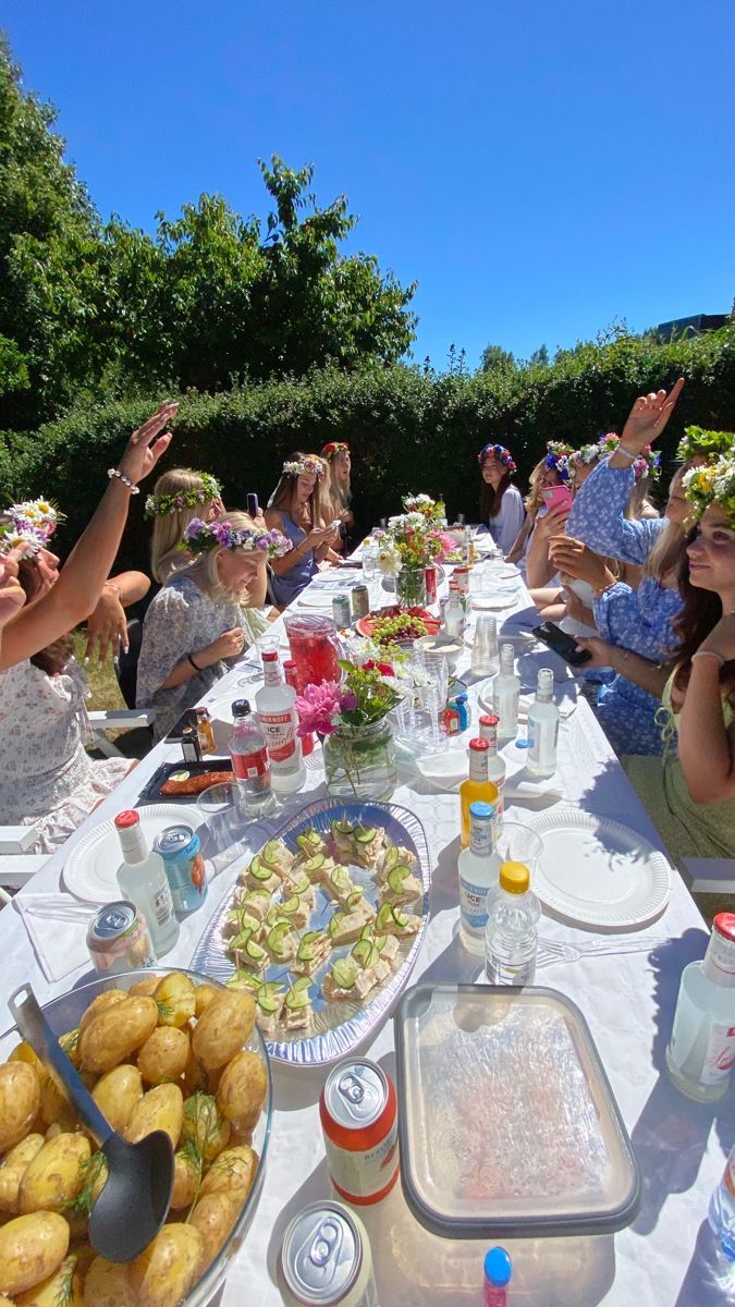 a group of people sitting around a table with food on it