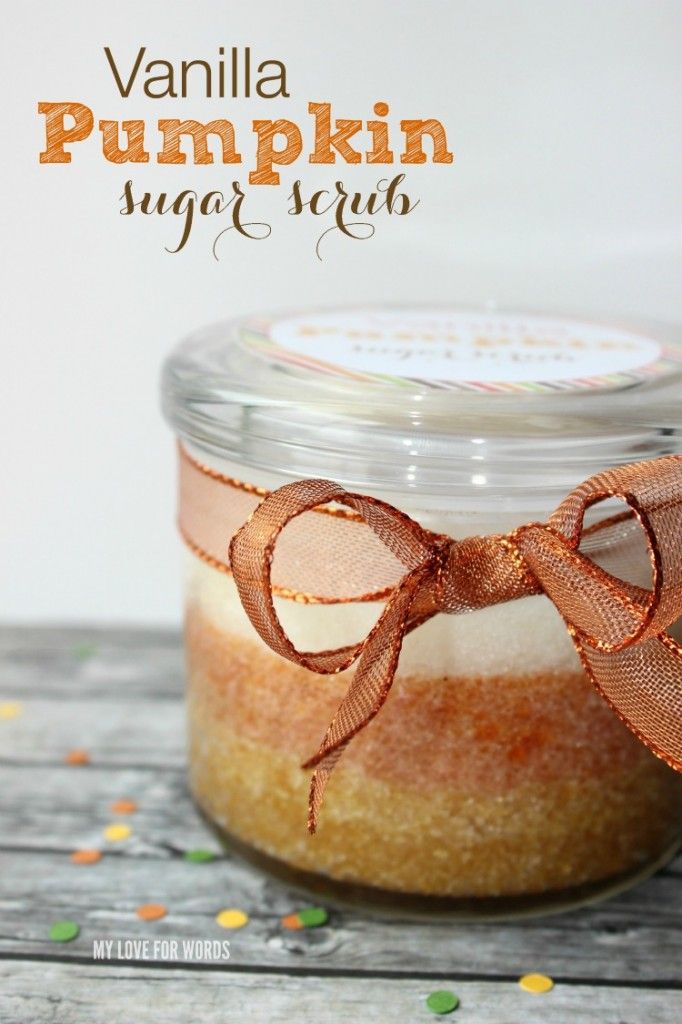 a jar filled with pumpkin sugar scrub sitting on top of a wooden table next to an orange ribbon