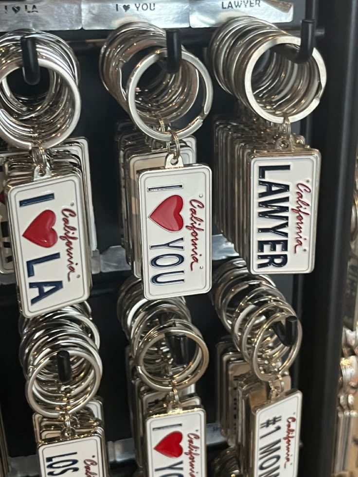 there are many key chains hanging on the rack in this store that says i love you