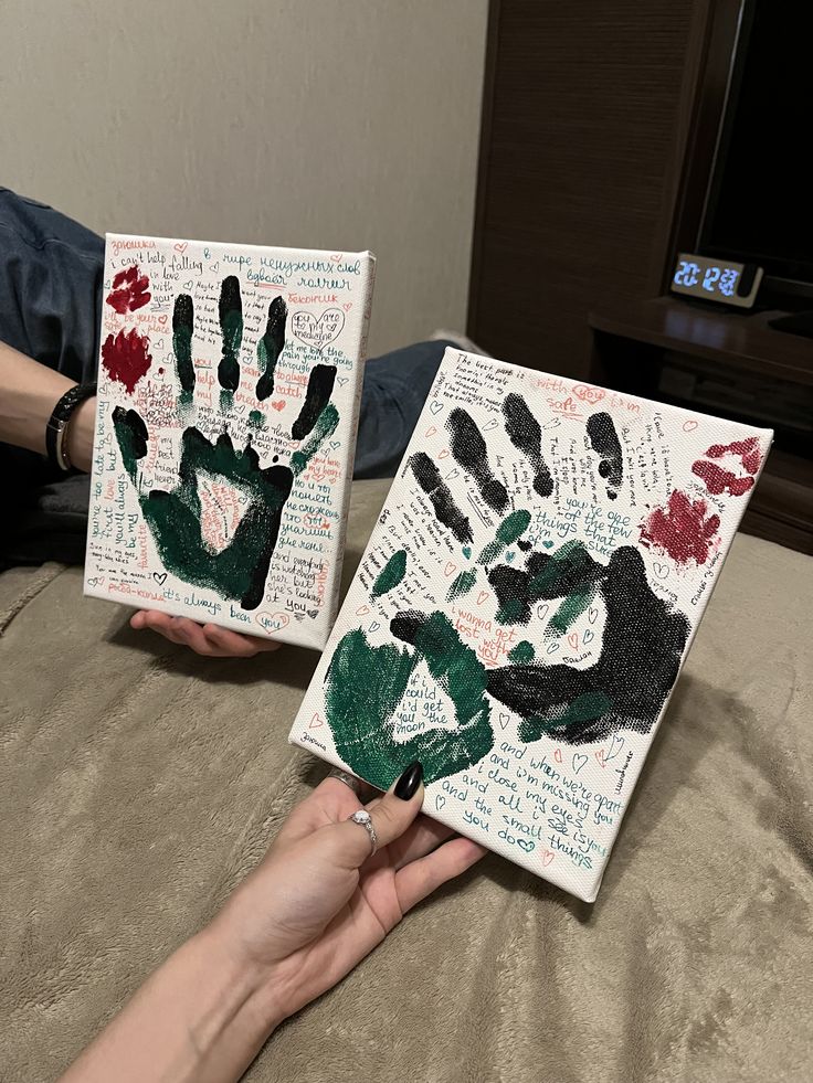 two people holding up handprints made from letters and words on paper with their hands