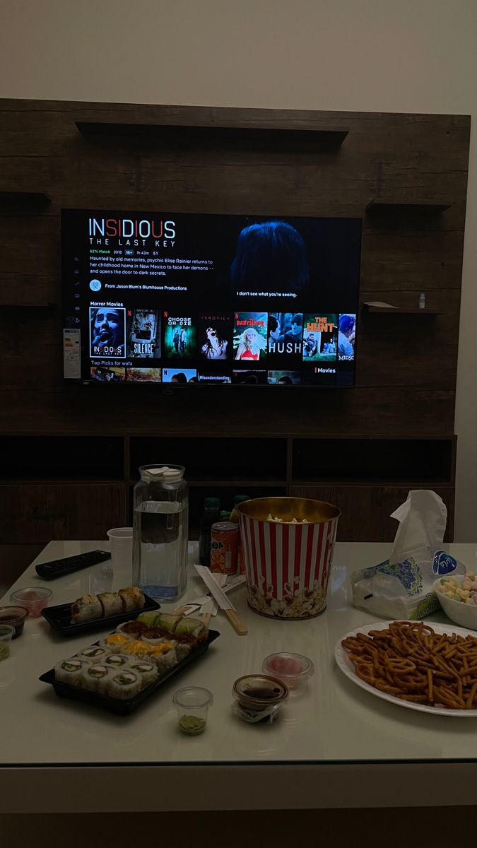 a table topped with plates of food next to a flat screen tv