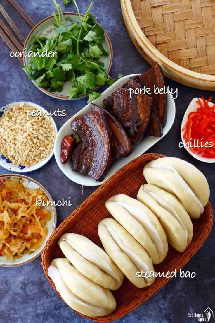 an assortment of food that includes meat, vegetables and sauces on a table with chopsticks