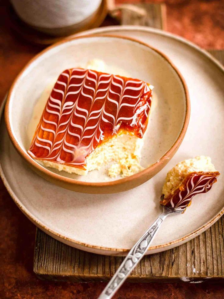 a piece of cake sitting on top of a white plate next to a fork and spoon