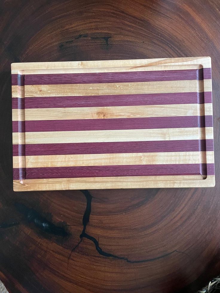 a wooden cutting board with purple and white stripes