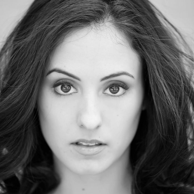 a black and white photo of a woman's face with long dark brown hair