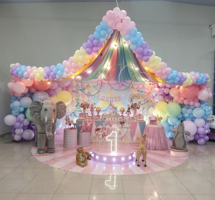 an elephant themed birthday party setup with balloons and decorations on the ceiling, including a carousel