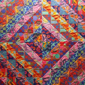 a colorful quilt is displayed on the wall