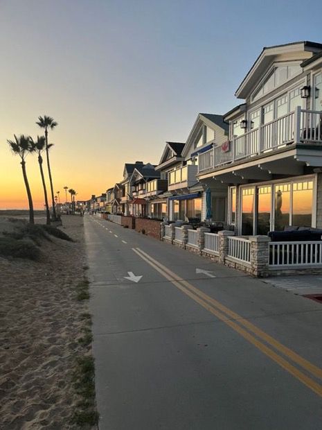 a row of houses on the beach at sunset