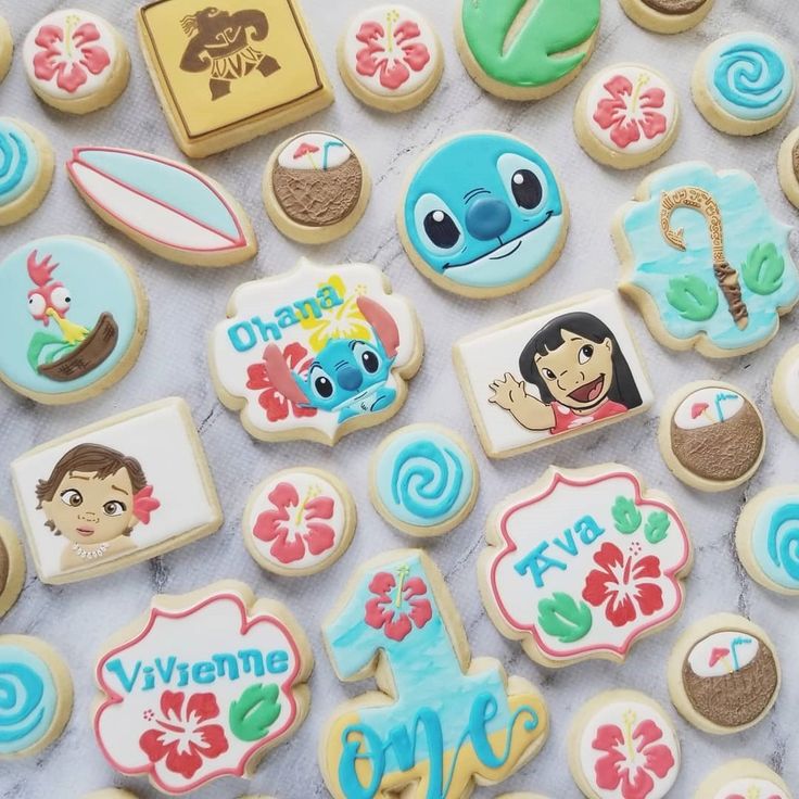 decorated cookies are displayed on a white tablecloth in this close up photo, with the words welcome to me surrounded by images of people and symbols