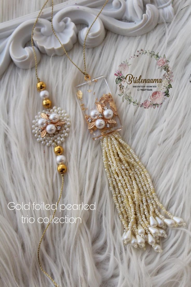 two necklaces with pearls and gold beads on a white furnishe background,