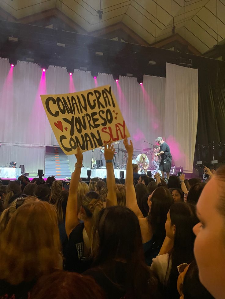 a group of people holding up signs at a concert