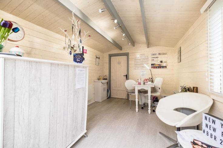 the inside of a small room with white furniture and decorations on the walls, along with wooden flooring