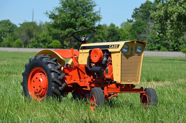 an orange tractor is parked in the grass