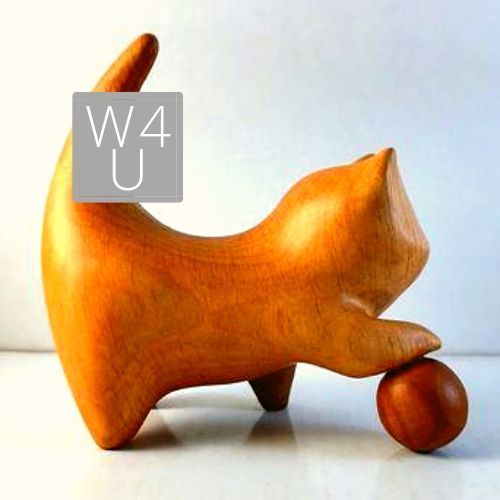 a wooden toy cat sitting on top of a table next to a red object with the word w4 u above it