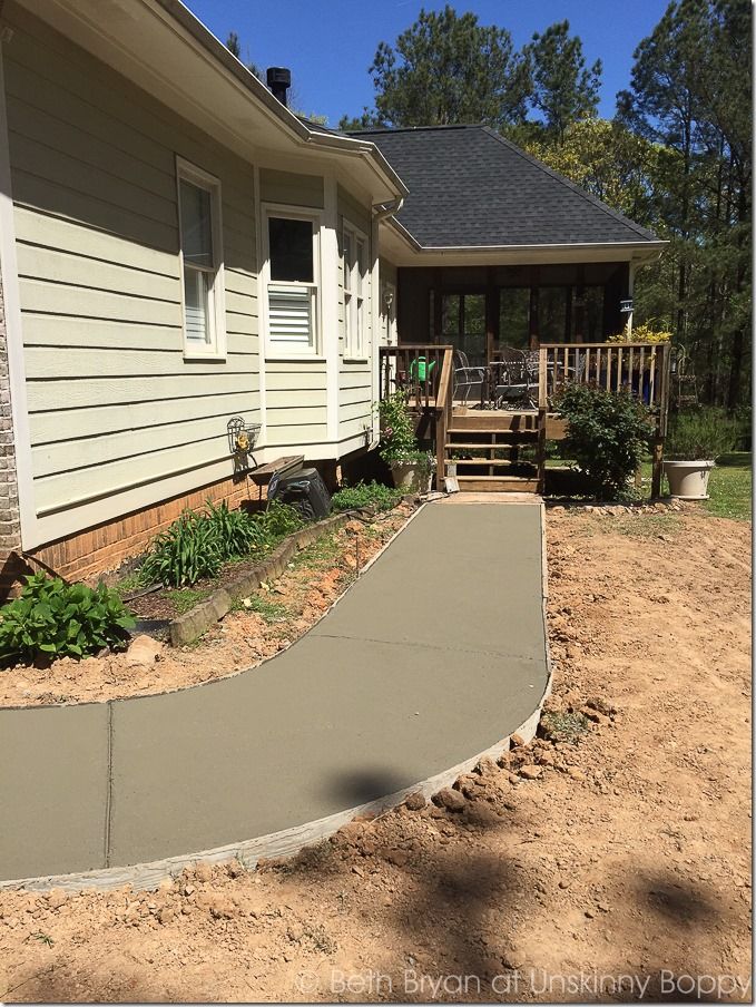 a concrete walkway in front of a house