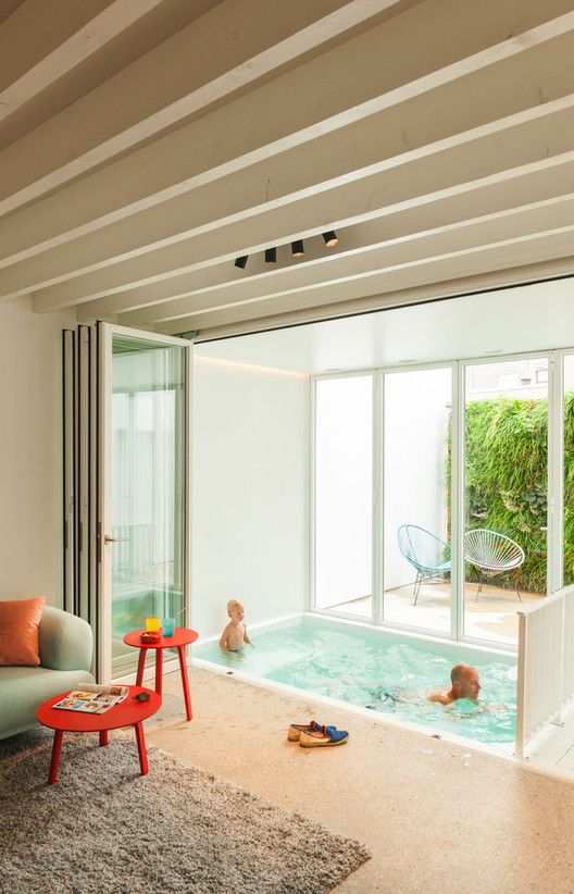 a living room filled with furniture and a swimming pool next to a sliding glass door