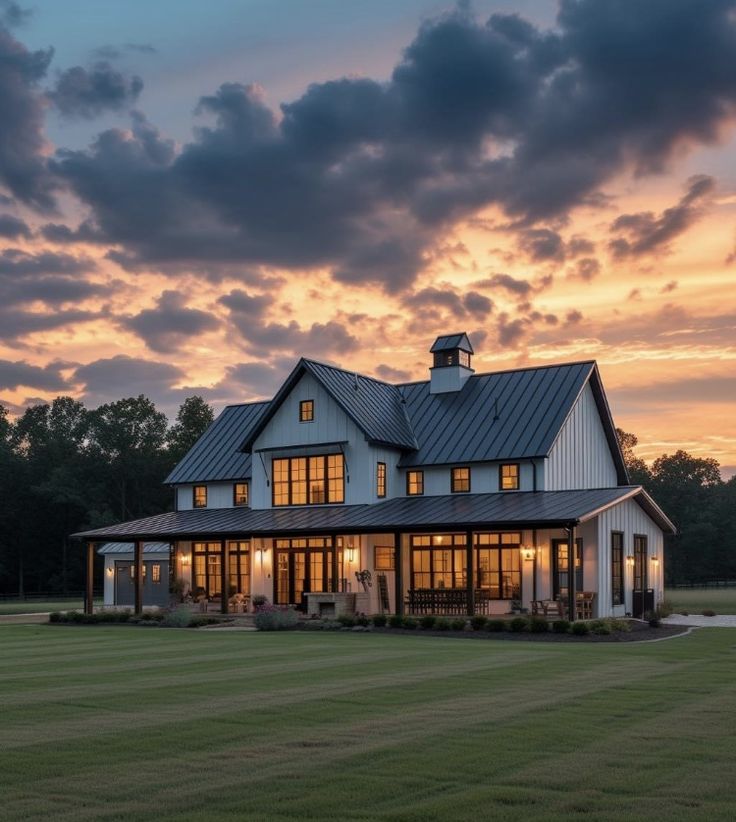 a large white house sitting on top of a lush green field under a cloudy sky