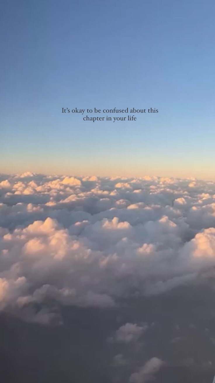 an airplane wing flying above the clouds with a quote on it's left side