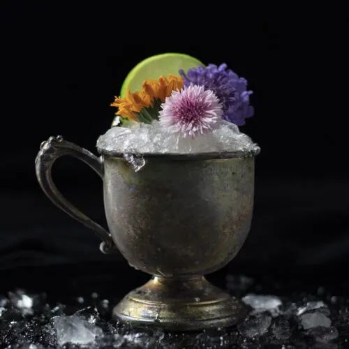 a silver cup filled with ice and flowers