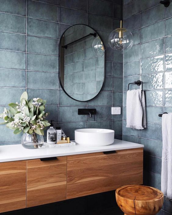 a bathroom with a sink, mirror and wooden stool